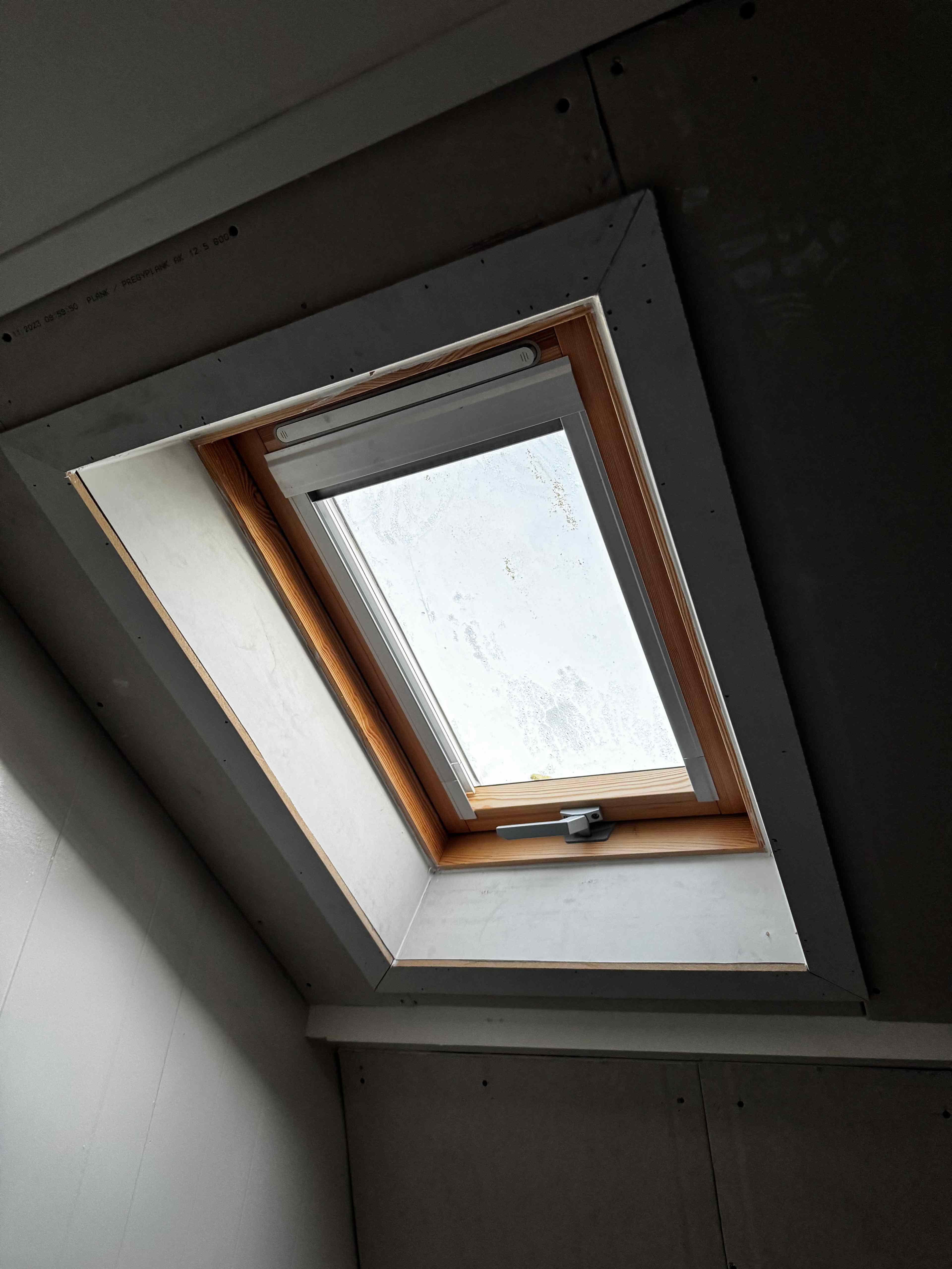 Houten dakraam met grenen frame gezien vanuit binnenzijde tijdens afbouw