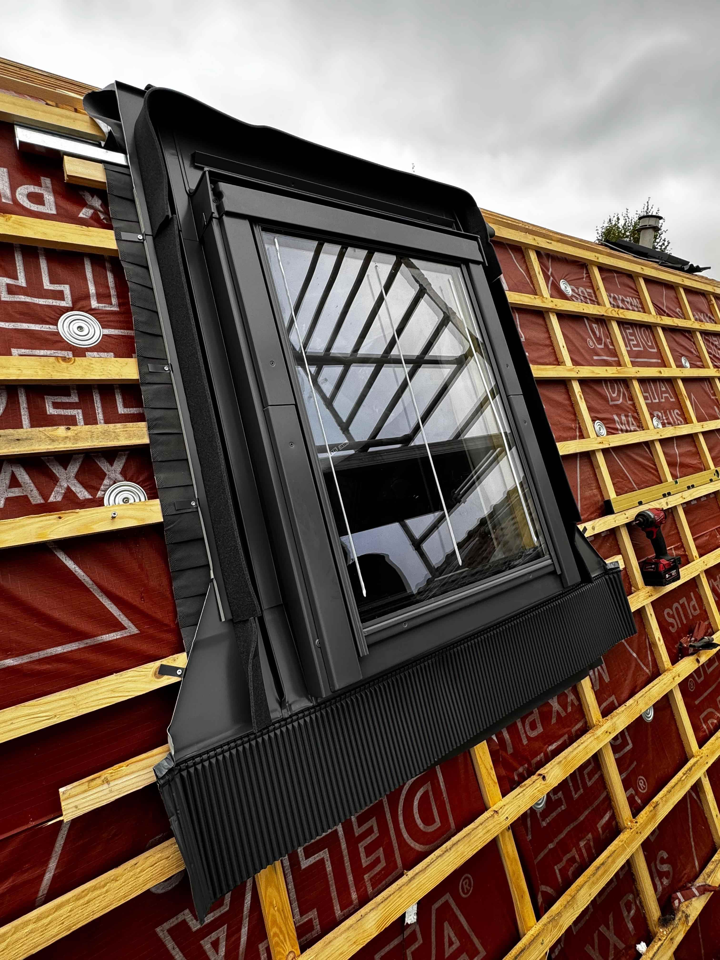 Zwart dakraam tijdens montage op dak met Delta folie en houten tengels