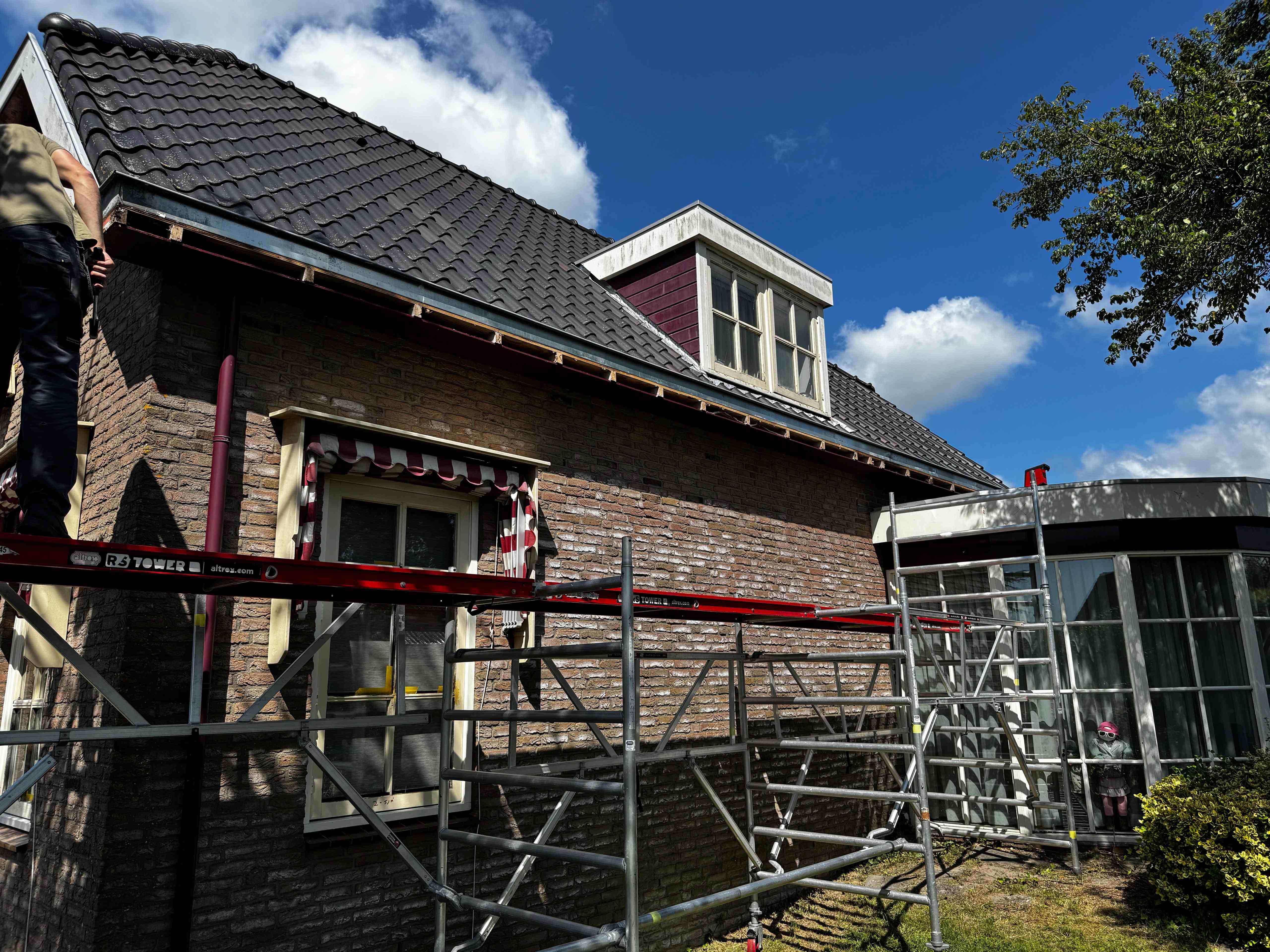 Steiger aan zijkant woning met dakkapel voor schilderonderhoud