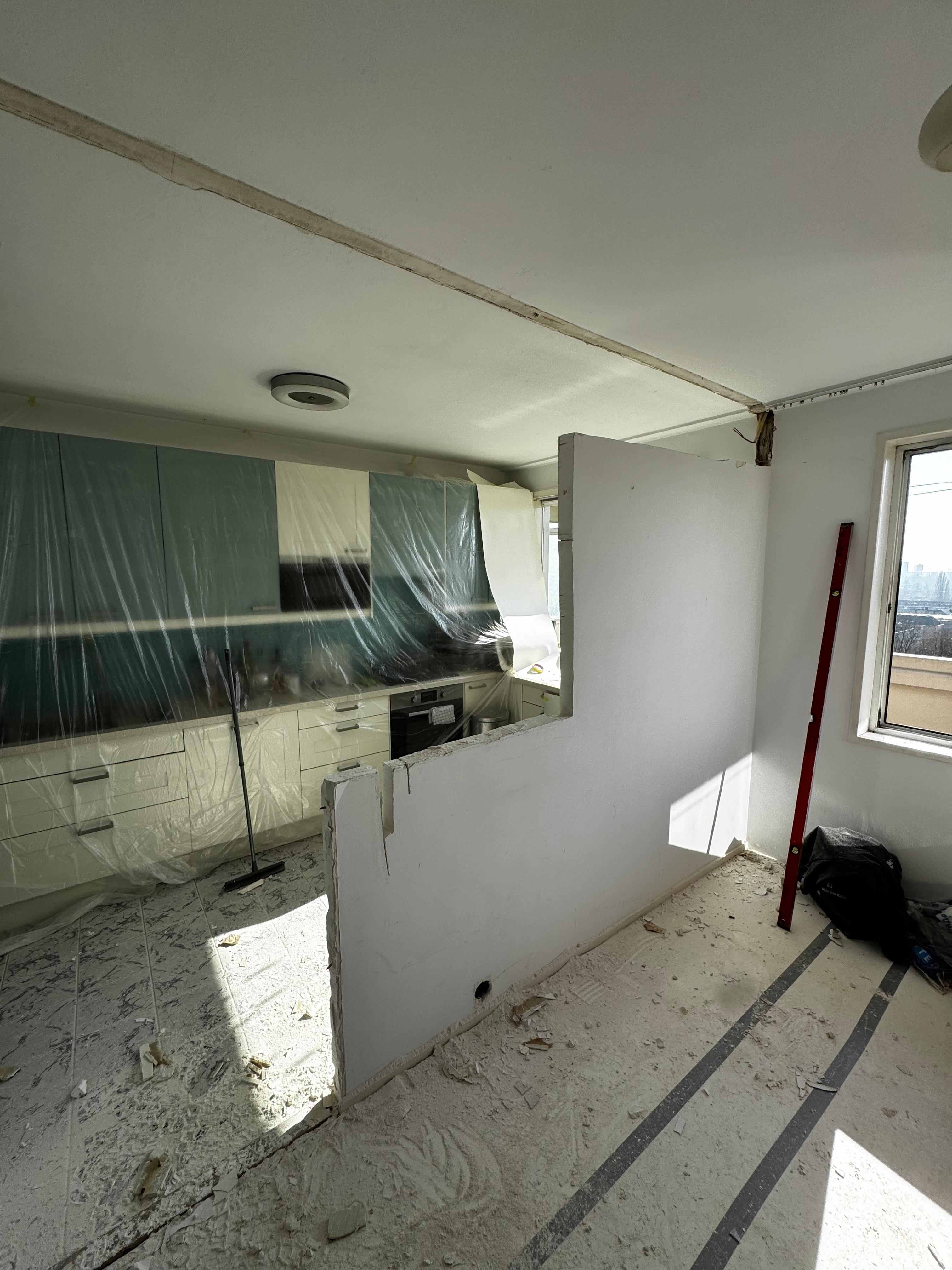Keuken tijdens sloopfase met gedeeltelijk verwijderde scheidingsmuur