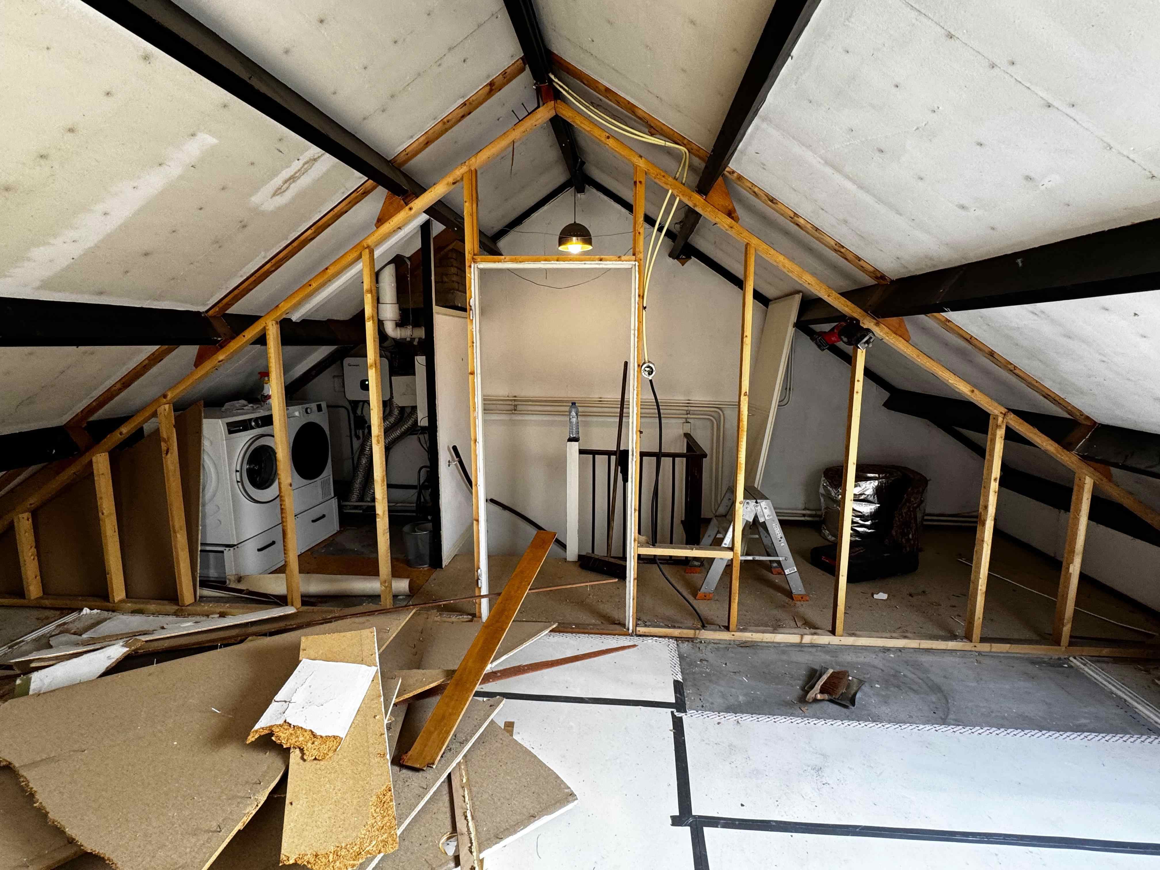 Zolder met houten skeletbouw en sloopmateriaal tijdens verbouwing