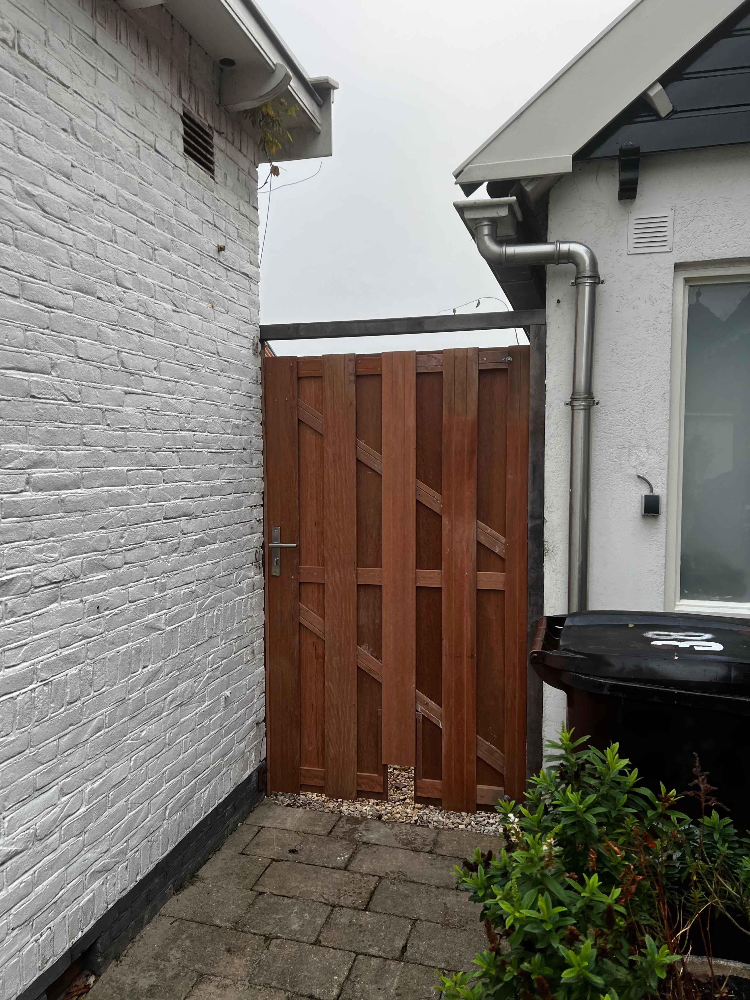 Hardhouten tuinpoort op maat tussen witte muren