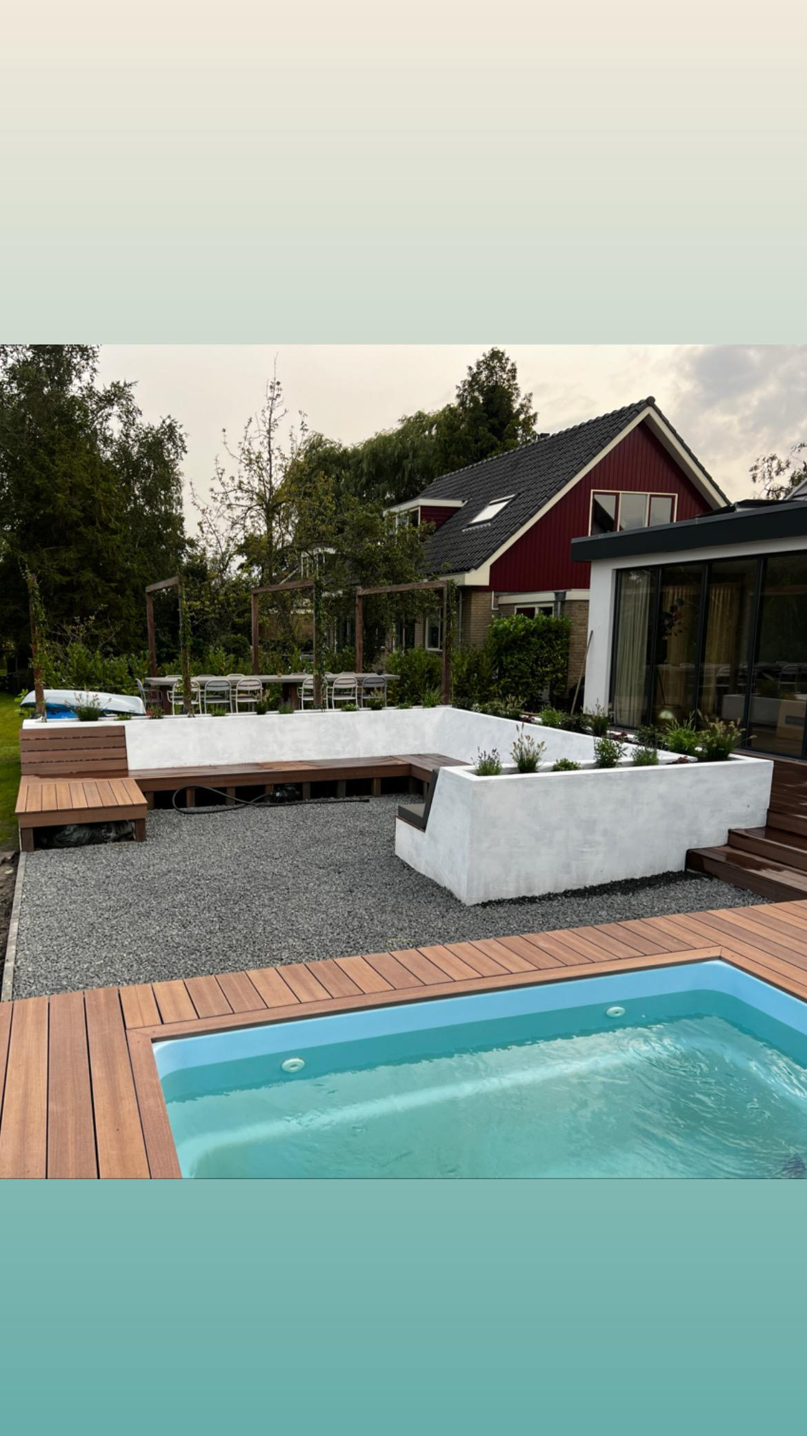 Tuin met zwembad, hardhouten vlonder en witte plantenbakken