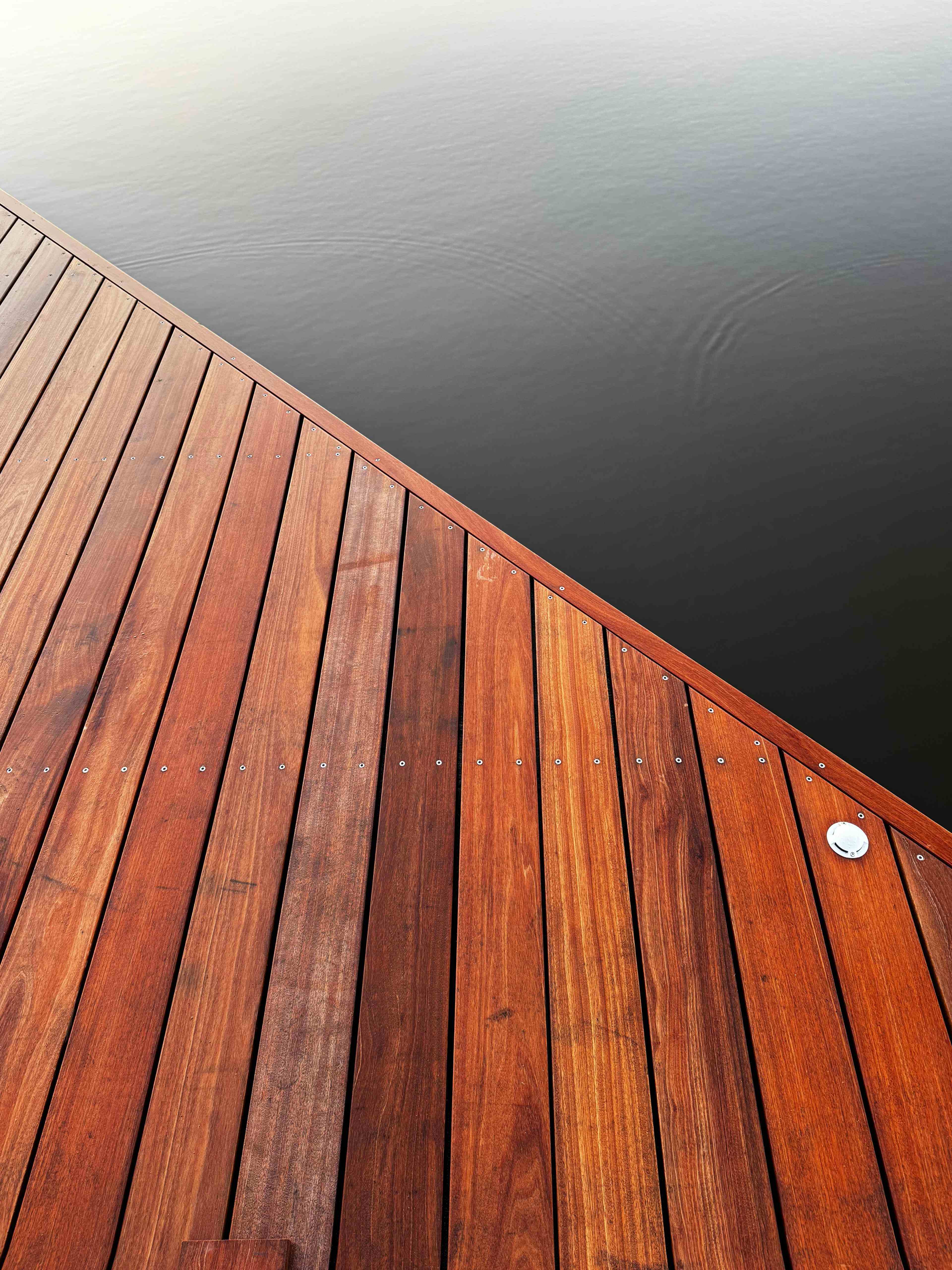 Detail hardhouten vlonderplanken met inbouwspot aan het water